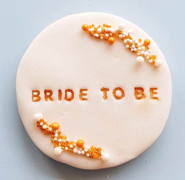 Fondant covered sugar cookies with "Bride to be" stamped on them
