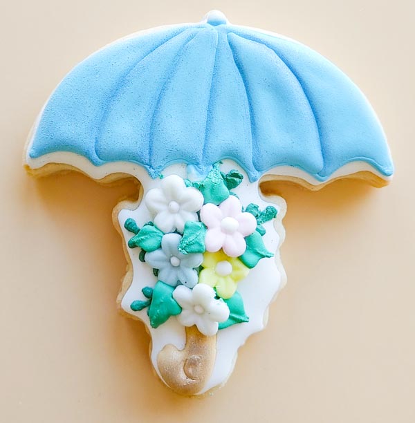 Blue umbrella sugar cookie with fondant floral accents