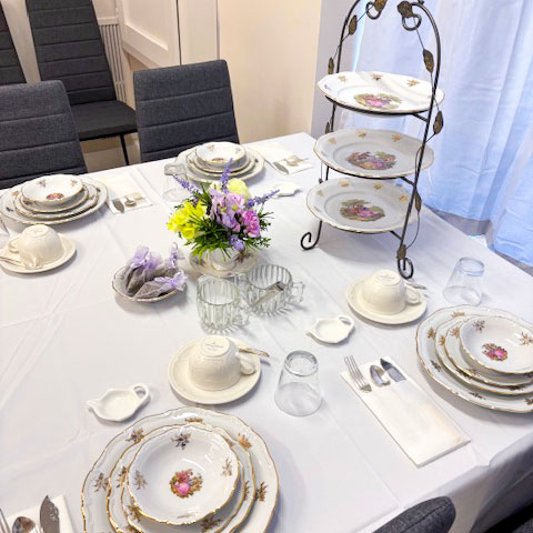 set-table a table in the Eat My Sweets event space set for four with fine china, ready for an English Afternoon Tea service