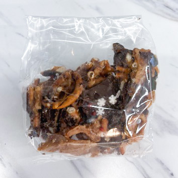 A packet of Christmas brittle: Homemade caramel covering pretzels topped with chocolate and sprinkles